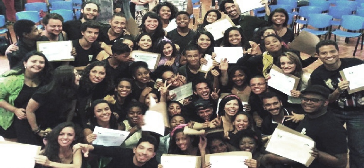 A large group of young people celebrating with certificates.