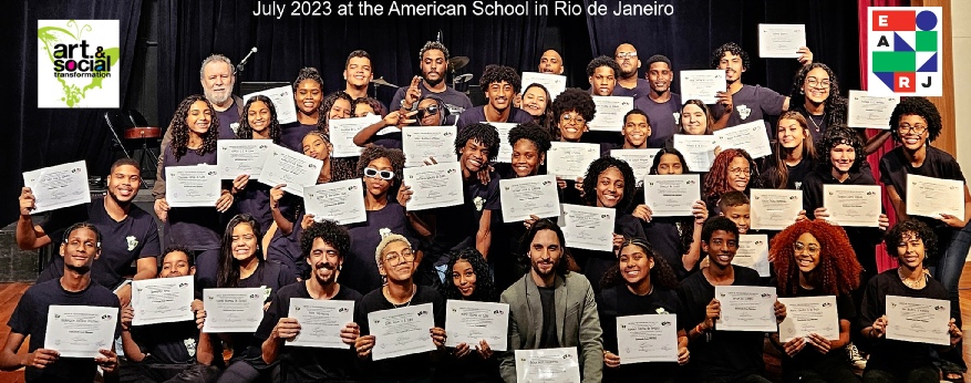 Participants and INSTIGartIVATORS of Arts & Social Transformation holding certificates on stage at the American School in Rio de Janeiro, July 2023.