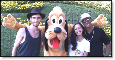 Young artists posing with a Pluto character on tour in the US.